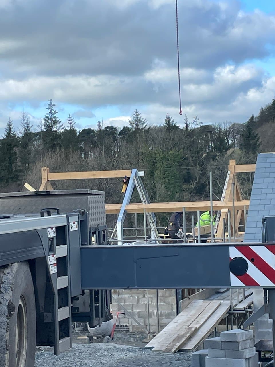 Steel beam and timber truss framework being assembled during large residential new build construction