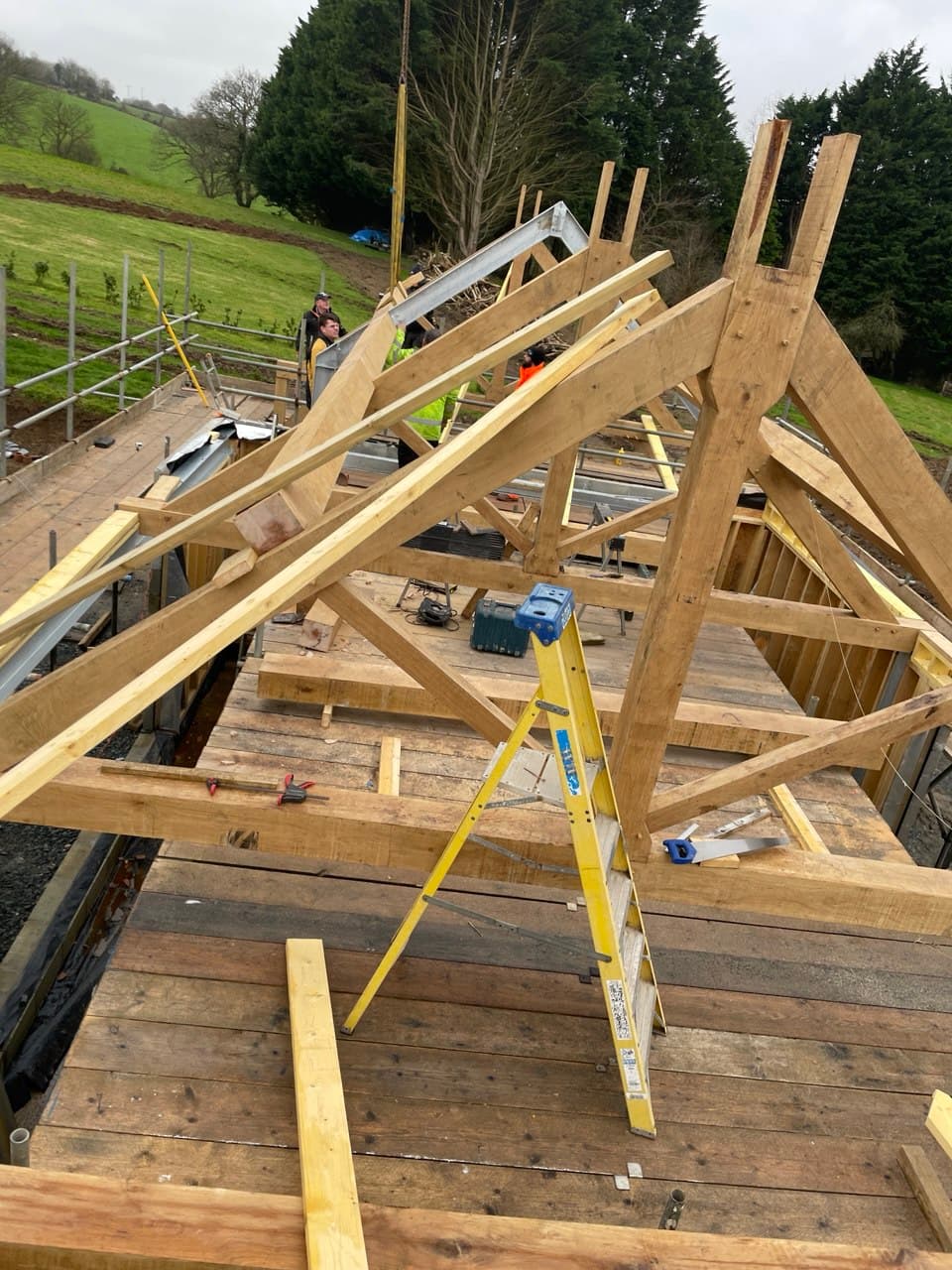 Elevated view of oak timber roof trusses and rafters during residential new build in Devon countryside