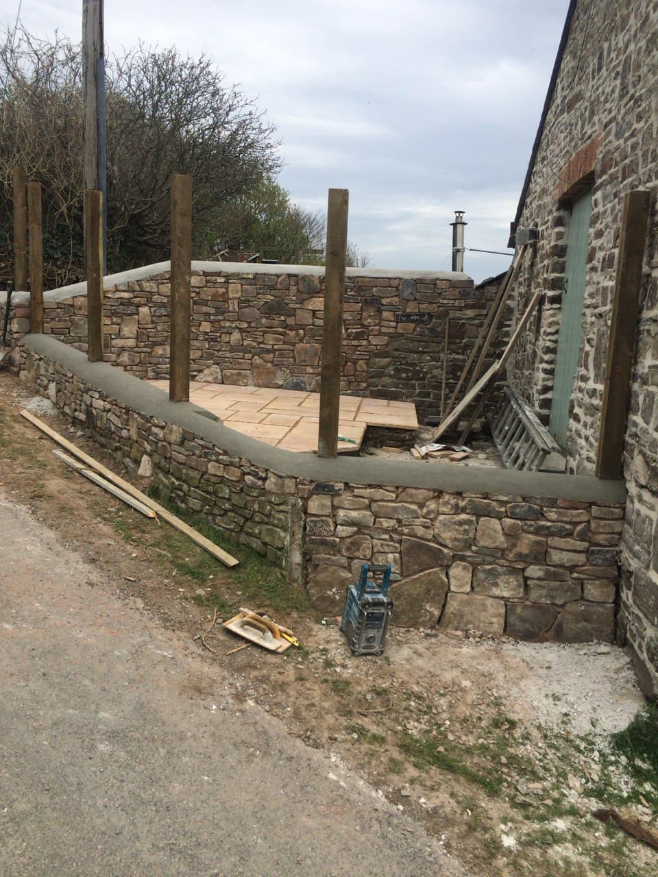Traditional natural stone retaining wall and patio built with local stone and lime mortar in North Cornwall by Spiby Build
